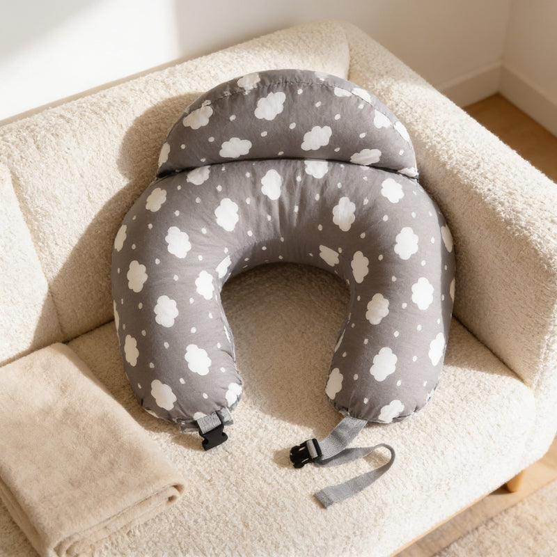 Gray cloud-print U-shaped nursing pillow with waist strap on a cream sofa.