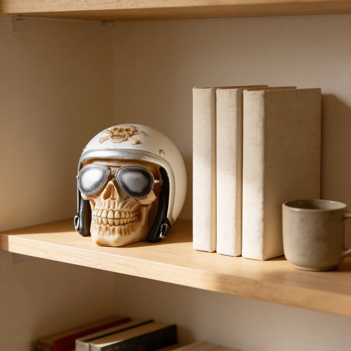 Helmet and sunglasses skull figurine on an oak bookshelf