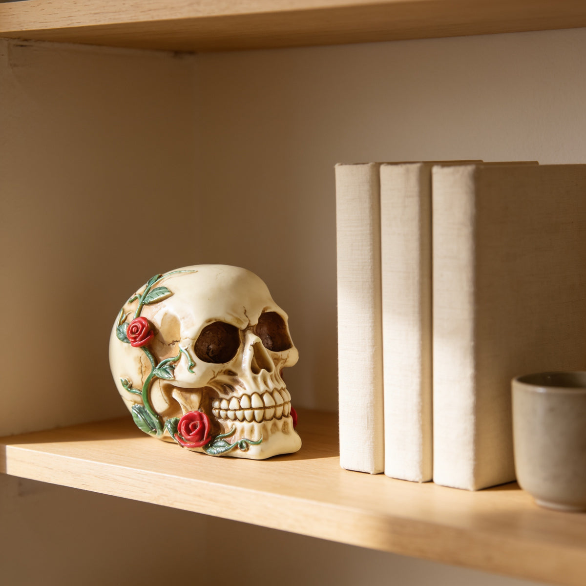 Roses skull figurine on an oak bookshelf