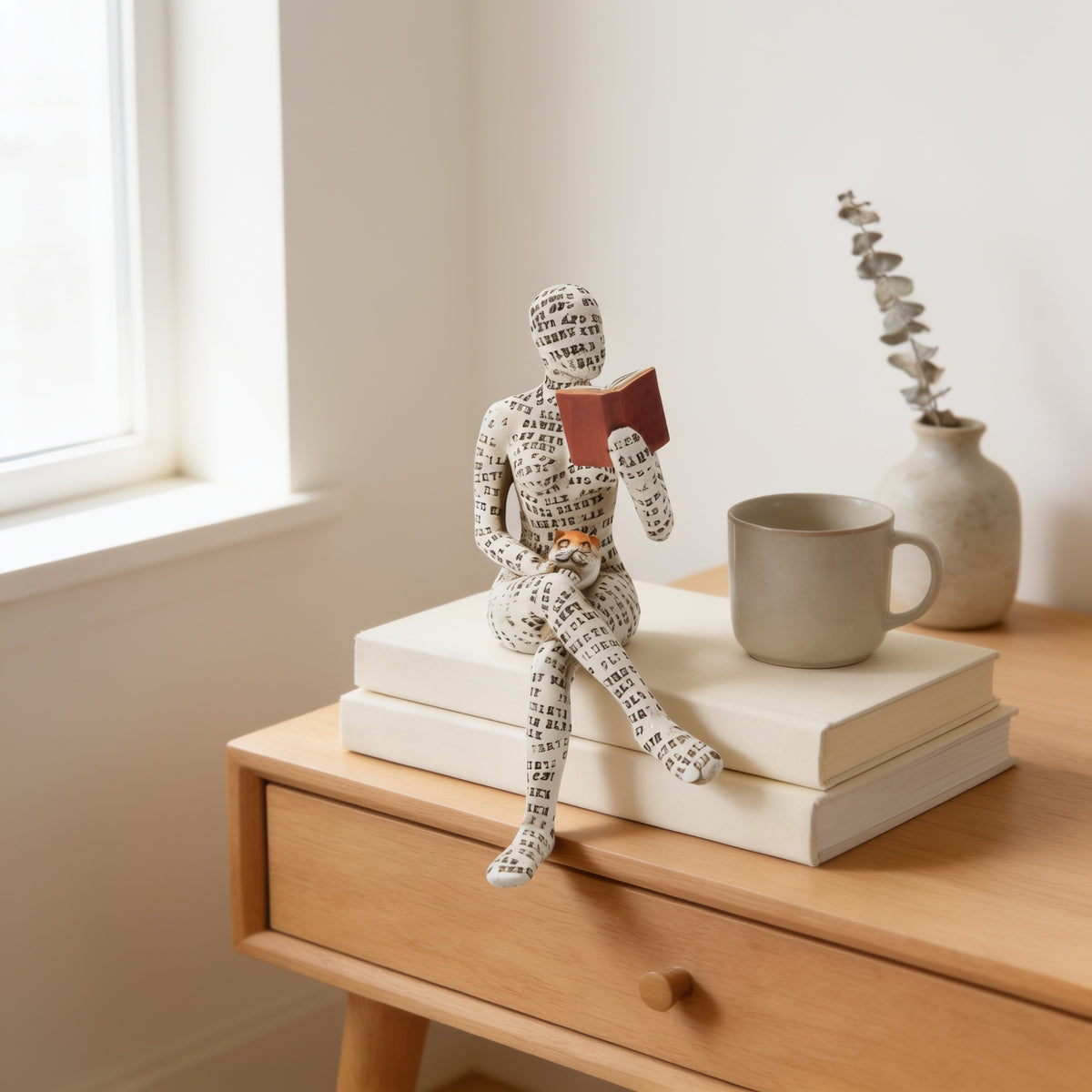 Seated legs-crossed paper-pulp reading figurine with red book on stacked books — Paper-Pulp Reading Figurine