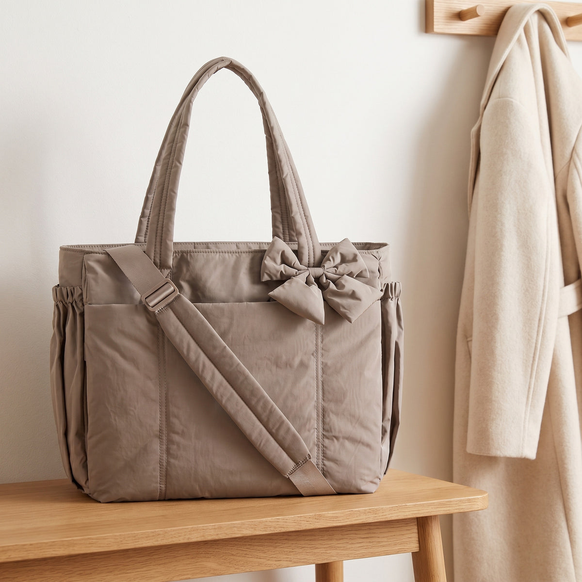 Taupe 15.6in puffer tote bag with its shoulder strap on an entryway bench