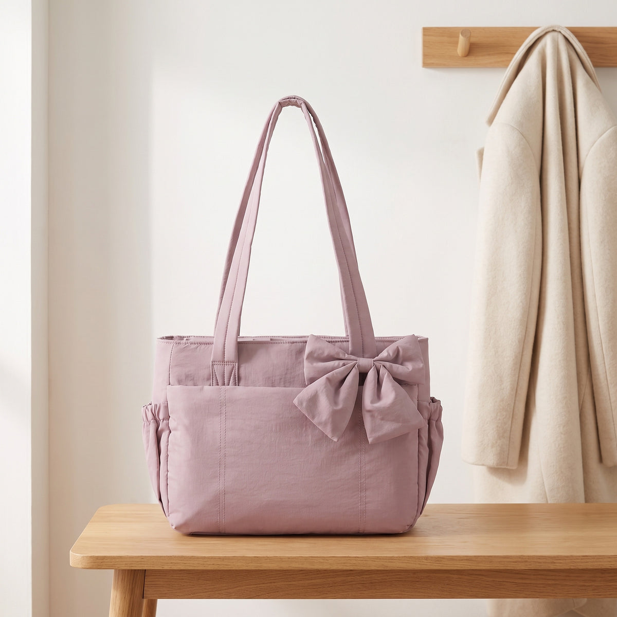 Dusty mauve puffer laptop tote bag with a bow on an entryway bench