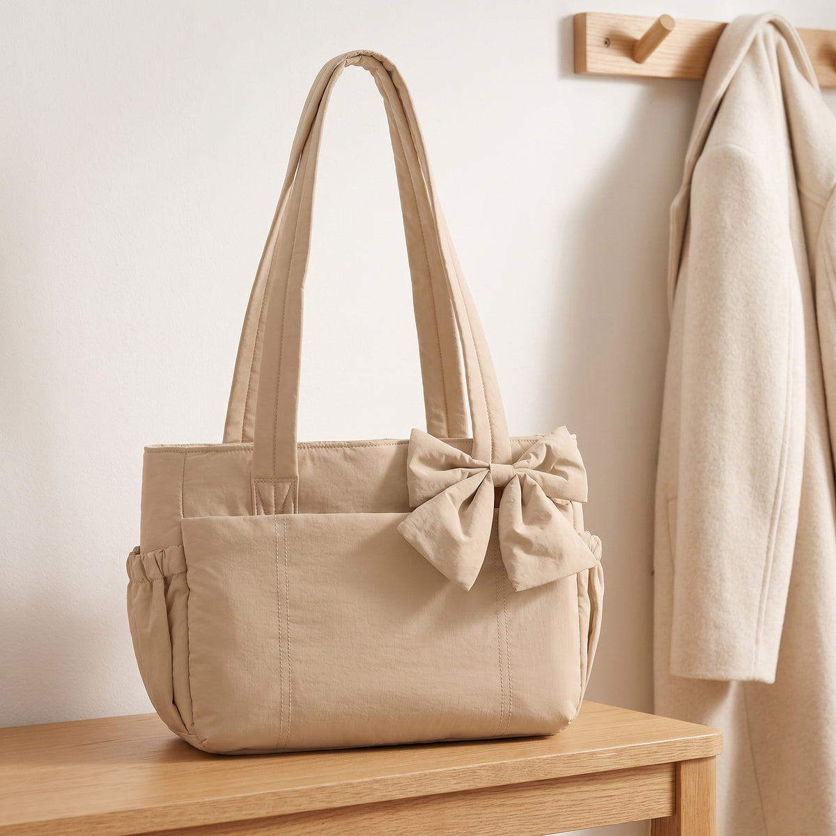 Sand puffer laptop tote bag with a bow on an entryway bench
