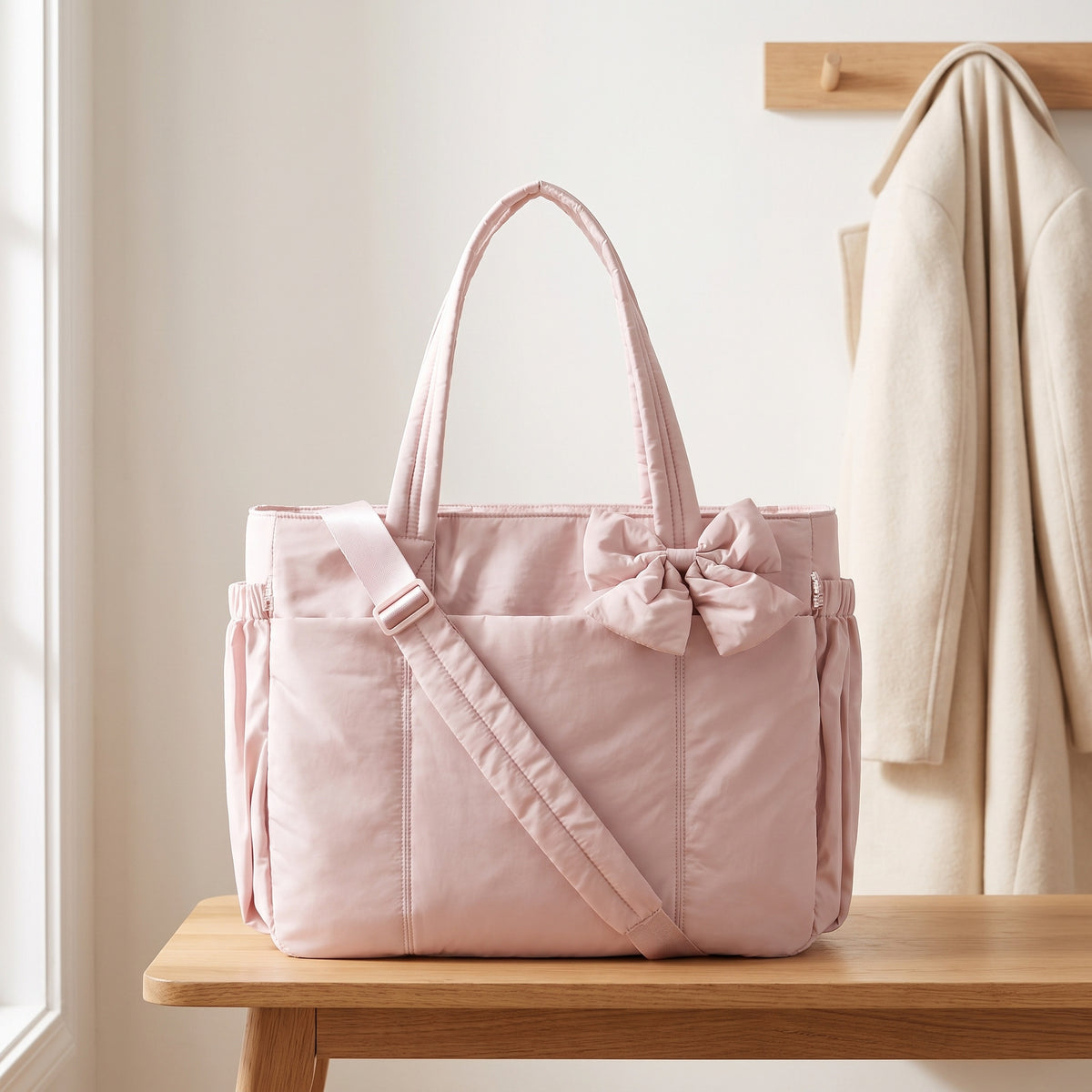 Pink 15.6in puffer tote bag with its shoulder strap on an entryway bench