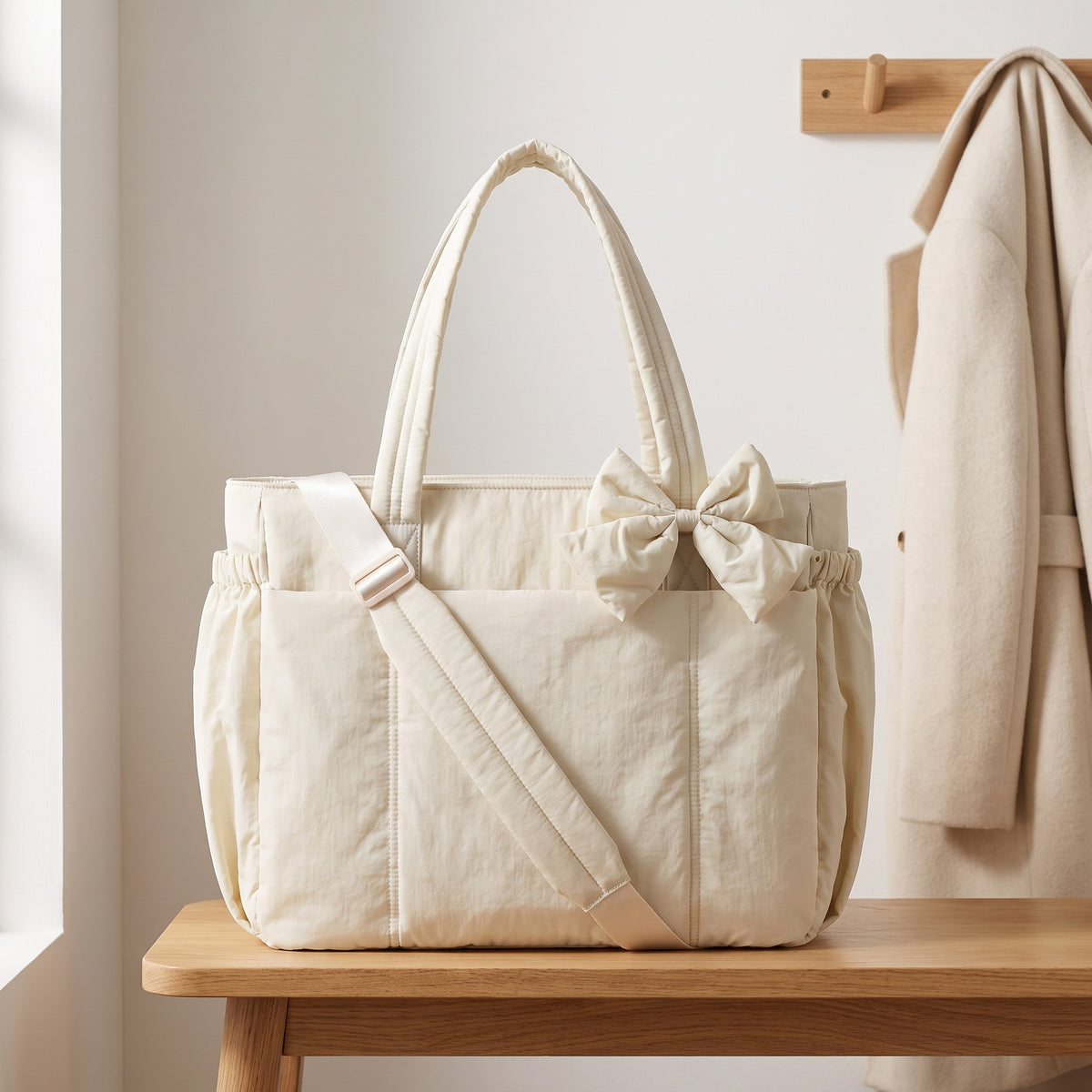 Cream 15.6in puffer tote bag with its shoulder strap on an entryway bench