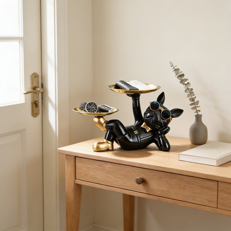 Black reclining French bulldog butler statue holding a round tray on an entryway console