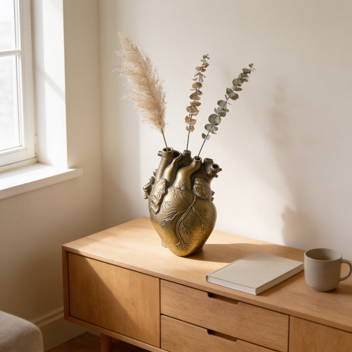 Gold resin anatomical heart vase with dried stems on an oak console — Resin Anatomical Heart Vase