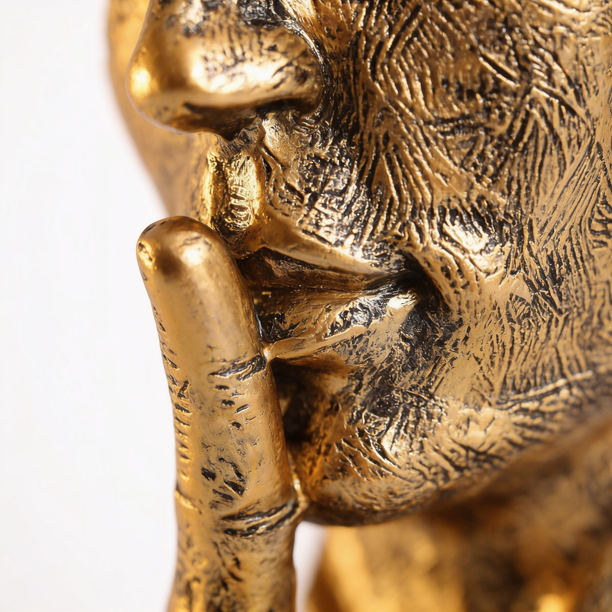 Close-up of the antique gold finger-to-lips detail — Silence Is Golden Thinker Statue