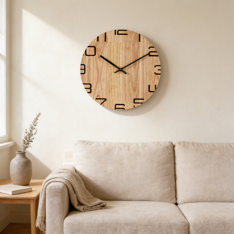 Round natural wood wall clock with bold numerals above a linen sofa — Silent Natural Wood Wall Clock