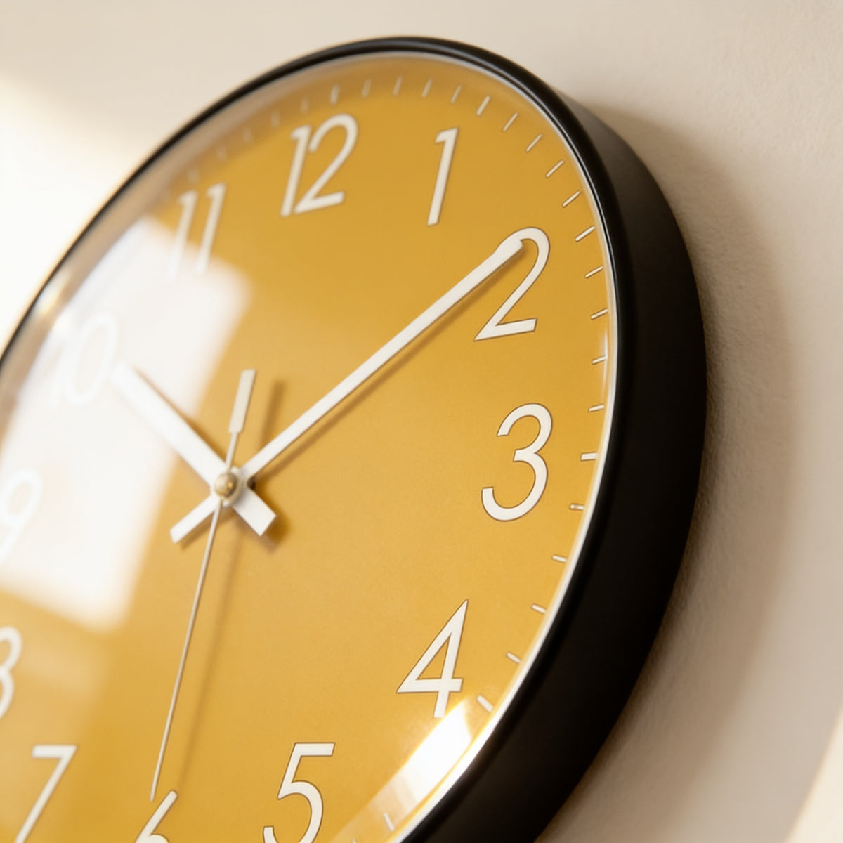 Close-up of the slim rim and mustard dial of the silent wall clock