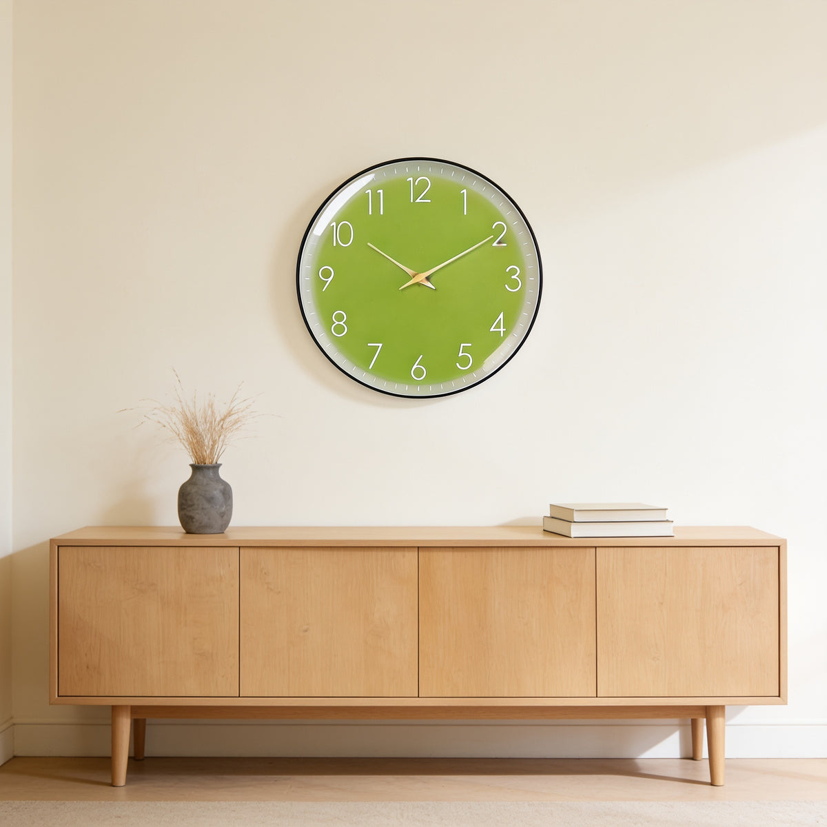 Apple green wall clock with a slim black frame above an oak sideboard