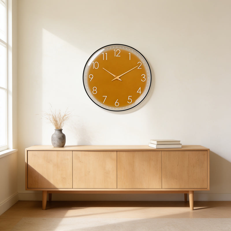 Mustard dial wall clock with a slim black frame above an oak sideboard