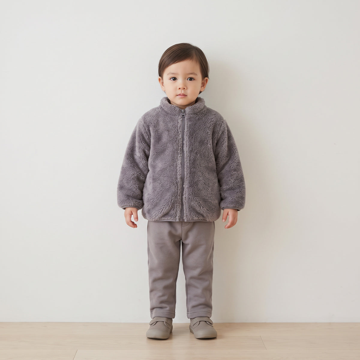 Toddler wearing the grey plush fleece jacket zipped to the collar, full length
