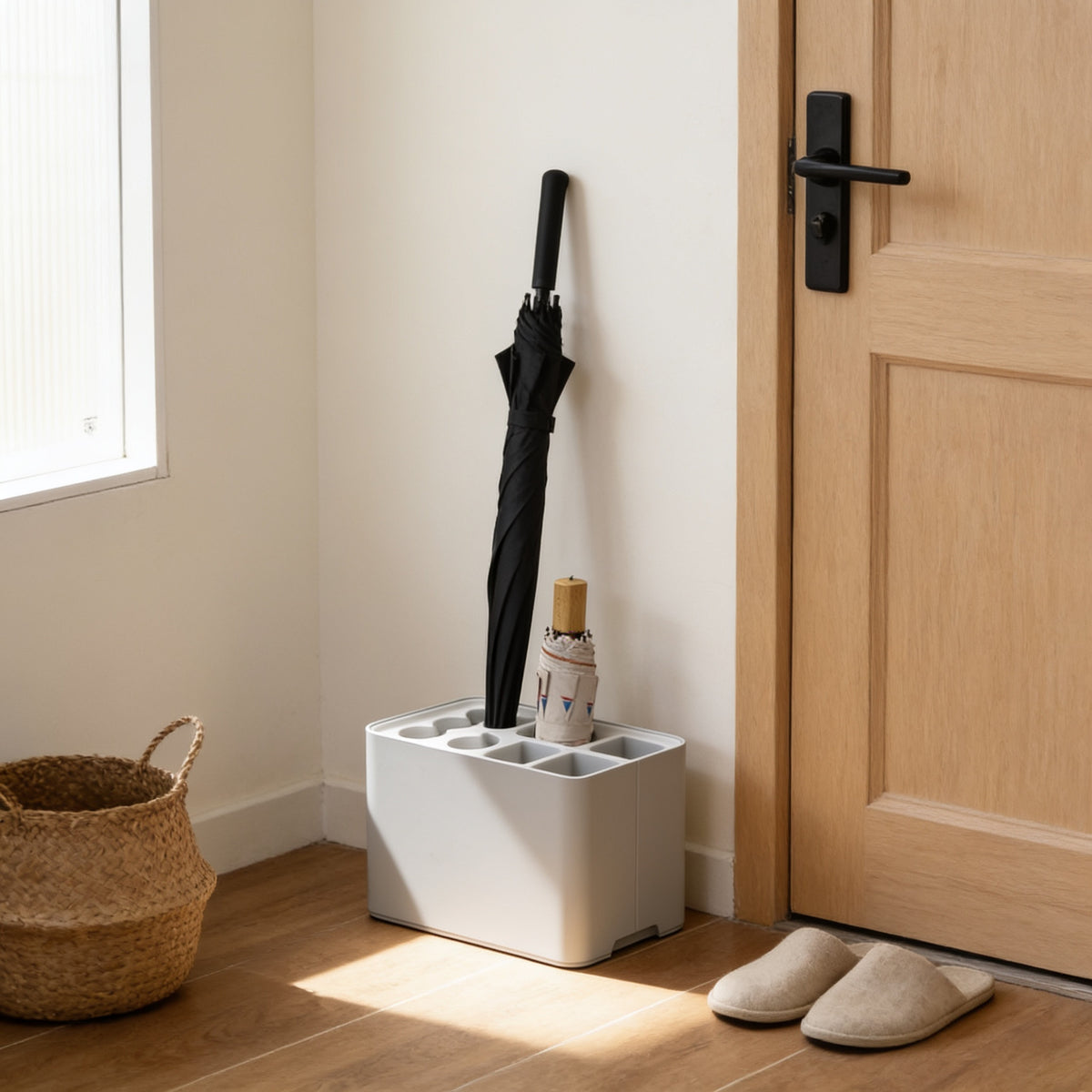 Light grey six-slot umbrella stand with drip tray by a front door