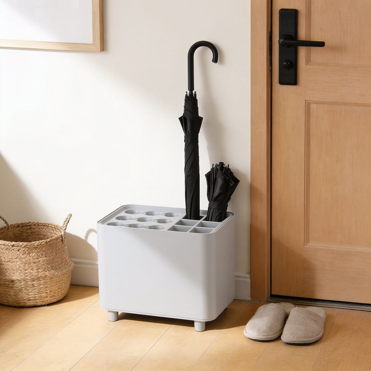 Light grey nine-slot umbrella stand with drip tray by a front door