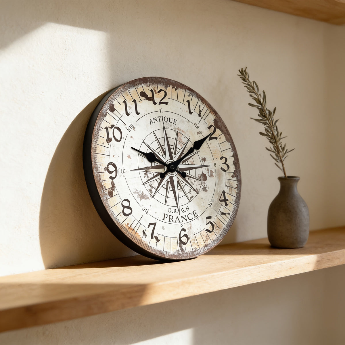 Vintage compass wall clock resting on an oak shelf beside a small vase