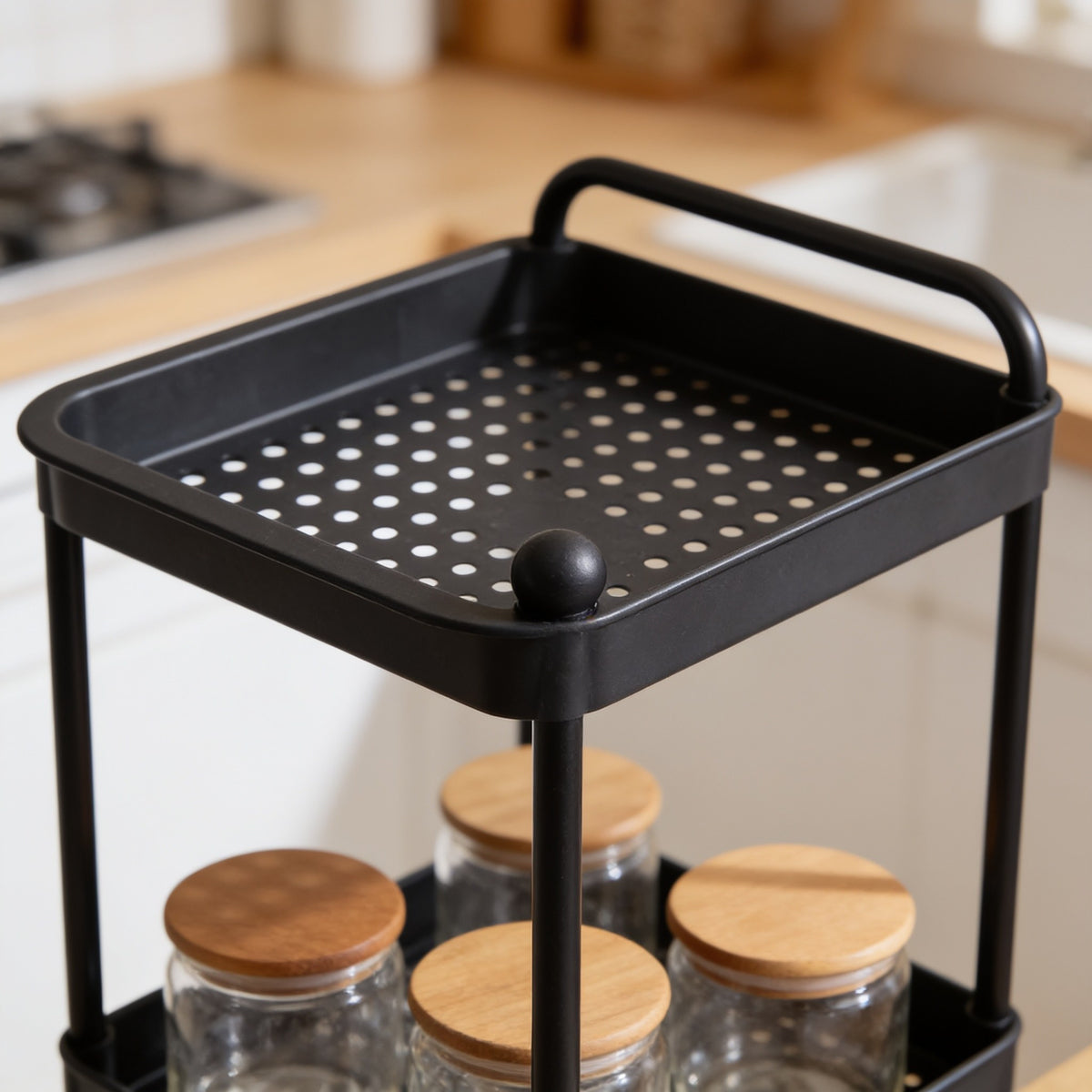 Close view of a black cart tray showing its raised lip and perforated floor.