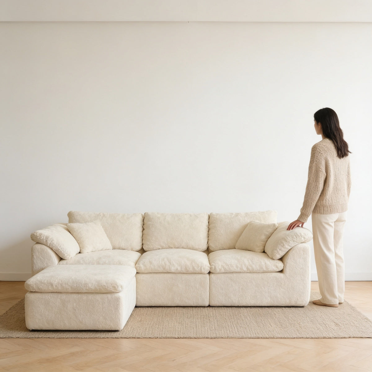 Adult standing beside the 278 cm cream cloud couch, its arm reaching only to mid-thigh.