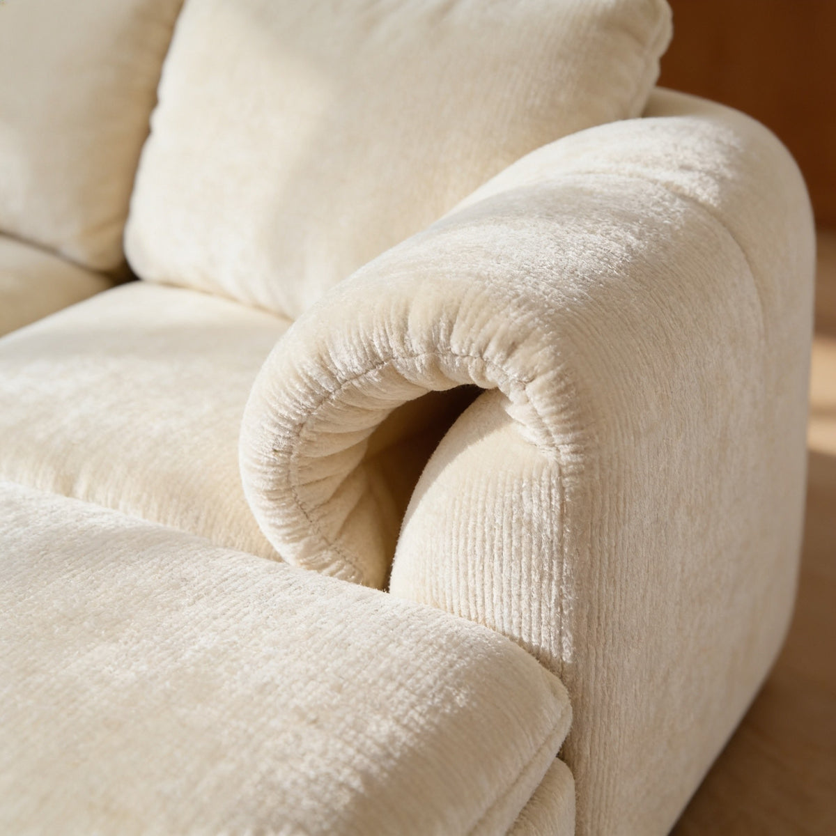 Close detail of the soft cream chenille over a plump rolled arm and seat cushion.