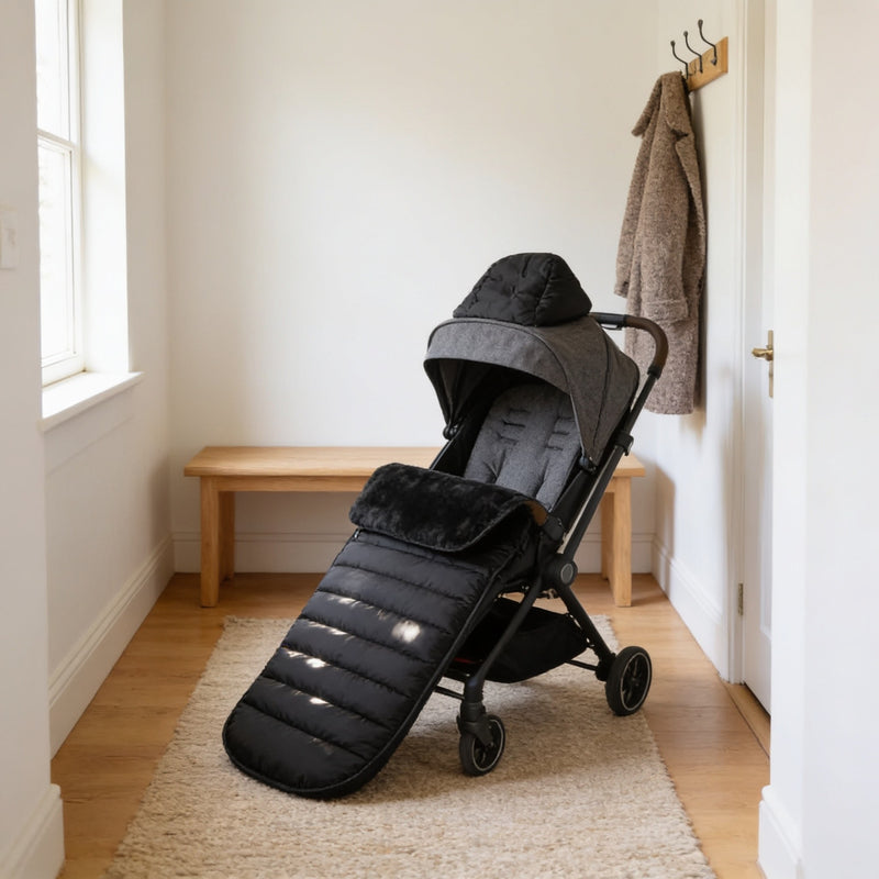 Black quilted fleece-lined bunting bag fitted in an empty pushchair in a warm hallway.