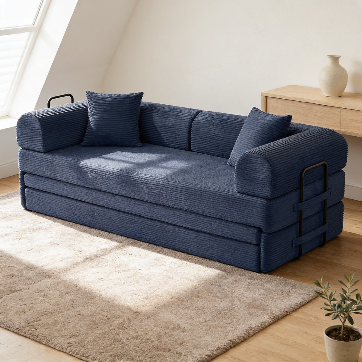 Navy blue corduroy convertible sofa bed in sofa mode in a warm living room.