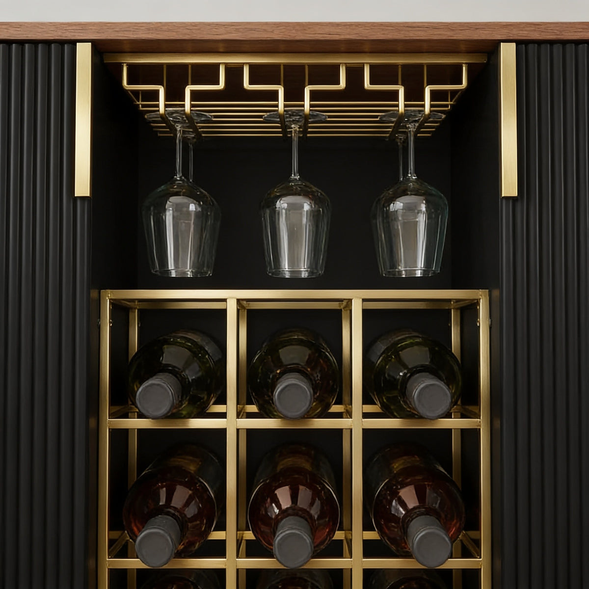 Close view of the cabinet's brushed gold stemware rail with hanging glasses above a gold three-by-three wine rack holding nine bottles.